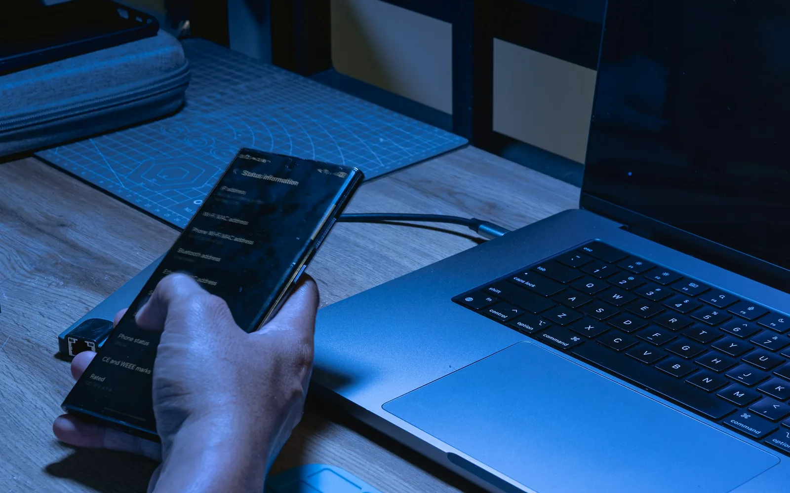 Developer testing a mobile application beside a laptop
